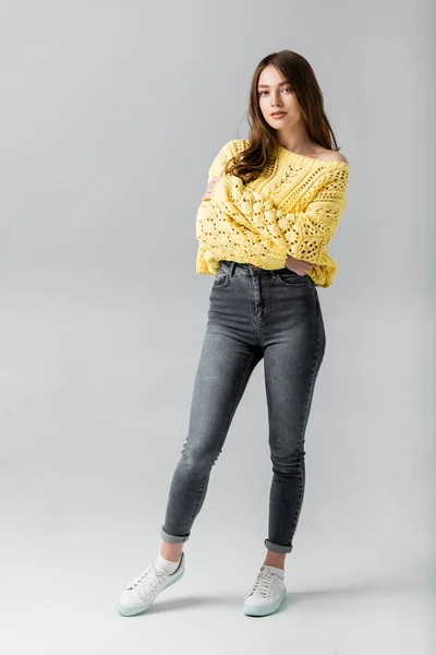 Attractive, confident woman looking at camera while standing on grey background — Stock Photo