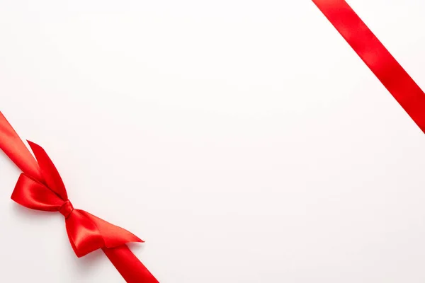 Top view of red satin ribbon with bow on white — Stock Photo