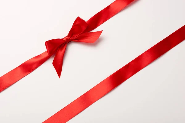 Top view of red ribbon with satin bow  on white — Stock Photo