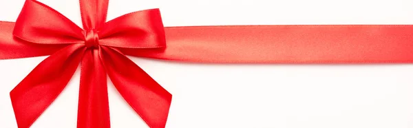 Panoramic shot of decorative red ribbon with bow isolated on white — Stock Photo