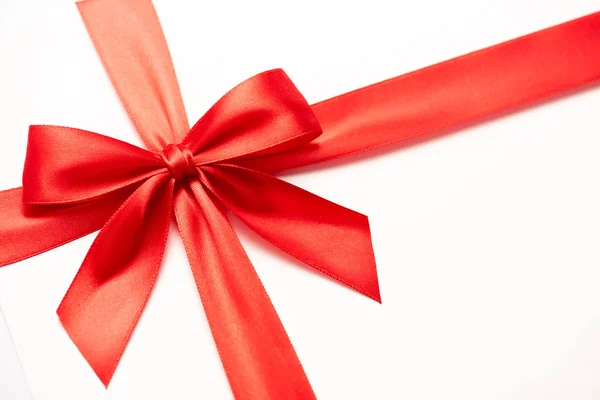 Close up of satin ribbon with red bow isolated on white — Stock Photo