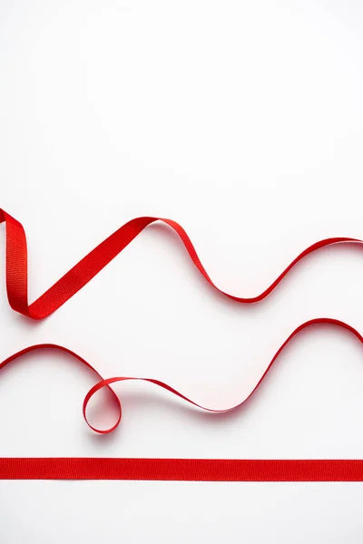 Top view of red curled ribbons on white with copy space — Stock Photo