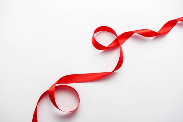 Top view of red curled ribbon on white with copy space — Stock Photo