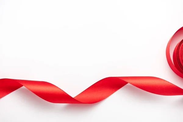 Draufsicht auf gerolltes und rotes Band auf weißem mit Kopierraum — Stockfoto