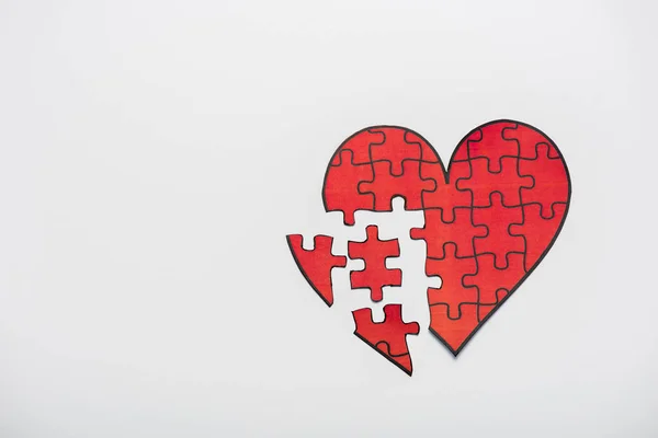 Vista superior de rompecabezas dibujado en forma de corazón rojo aislado en blanco - foto de stock
