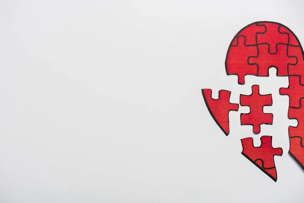 Vista superior del rompecabezas dibujado en forma de corazón rojo aislado en blanco con espacio de copia - foto de stock