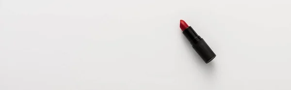 Panoramic shot of black tube with red lipstick on white with copy space — Stock Photo