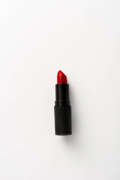 Draufsicht auf schwarze Tube mit rotem Lippenstift auf weißem mit Kopierraum — Stockfoto