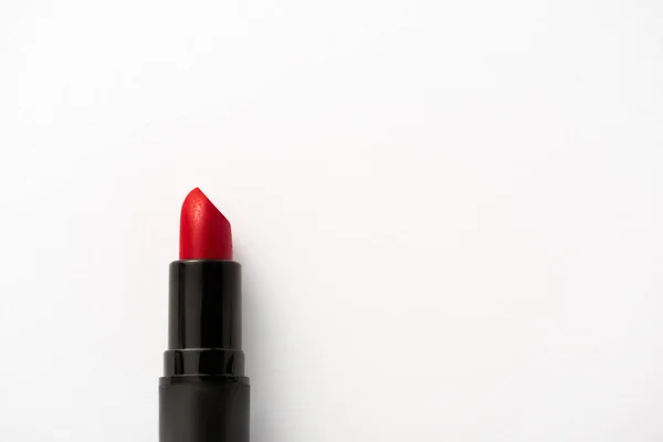 Vista superior del tubo negro con lápiz labial rojo sobre blanco con espacio para copiar - foto de stock