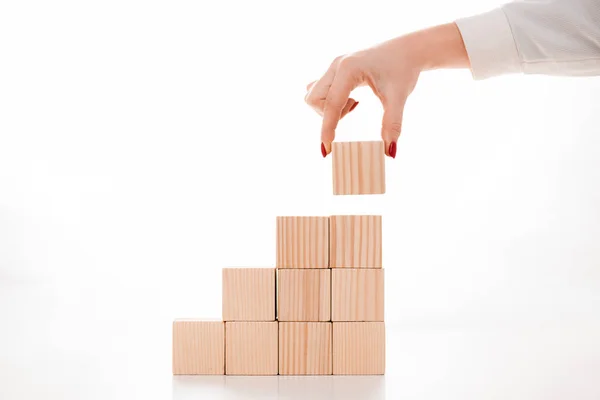 Cropped view of businesswoman holding wooden cube on white — Stock Photo
