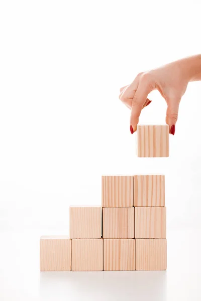 Vista ritagliata della donna mettendo cubo di legno su bianco — Foto stock