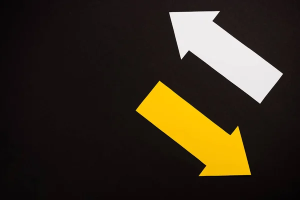 Top view of directional white and yellow arrows isolated on black — Stock Photo