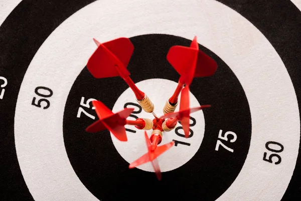 Vista superior del tablero de dardos en blanco y negro con flechas rojas - foto de stock