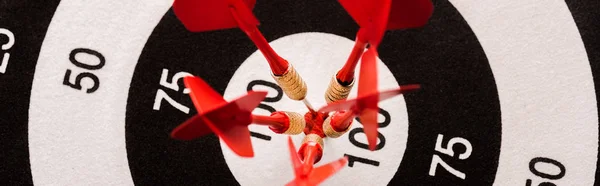 Panoramic shot of black and white dartboard with red arrows — Stock Photo