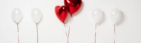 Панорамный снимок красных шаров в форме сердца на белом — стоковое фото
