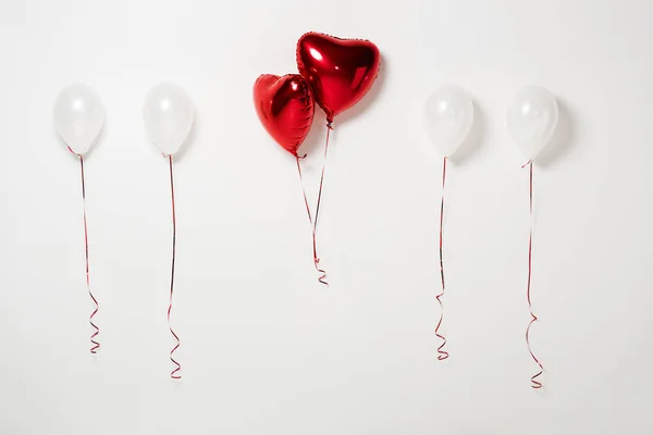 Globos de fiesta brillantes y rojos en blanco - foto de stock