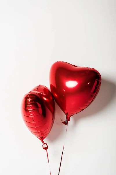 Red and shiny heart shaped balloons on white with copy space — Stock Photo