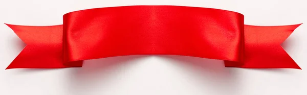 Tiro panorâmico de fita vermelha e cetim no branco — Fotografia de Stock