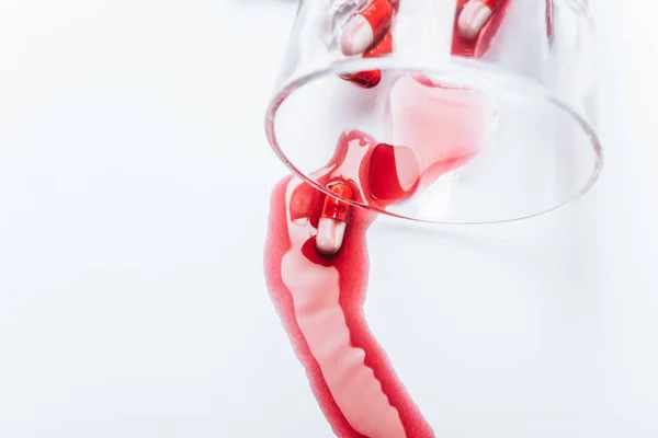 Umgekipptes Glas und feuchte Pillen in rotem Wasser auf weißem Hintergrund, Suizidpräventionskonzept — Stockfoto