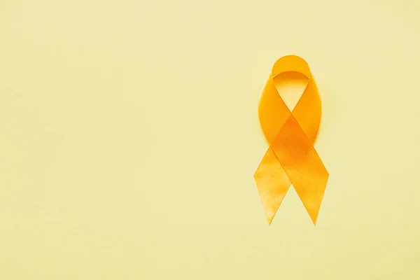 Vista superior de la cinta de conciencia amarilla sobre fondo amarillo, concepto de prevención del suicidio - foto de stock