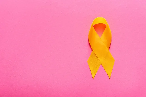 Visão superior da fita de consciência amarela em fundo rosa, conceito de prevenção de suicídio — Fotografia de Stock
