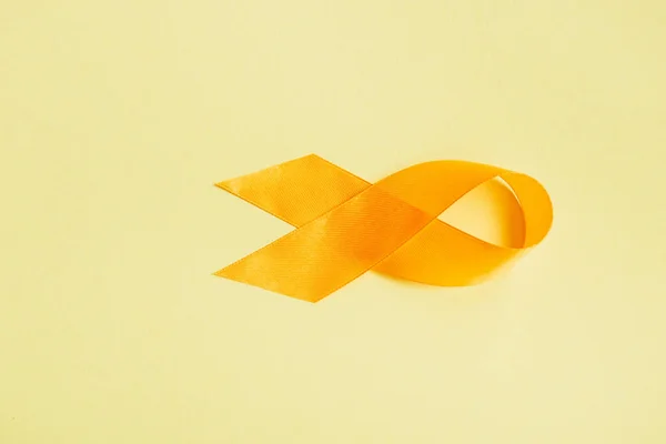 Vista superior de la cinta de conciencia amarilla sobre fondo amarillo, concepto de prevención del suicidio - foto de stock