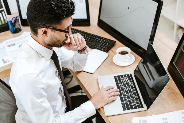 High angle view of pensive bi-racial trader using laptop — Stock Photo