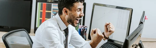 Tiro panorámico del comerciante bi-racial feliz mostrando sí gesto con los ojos cerrados - foto de stock