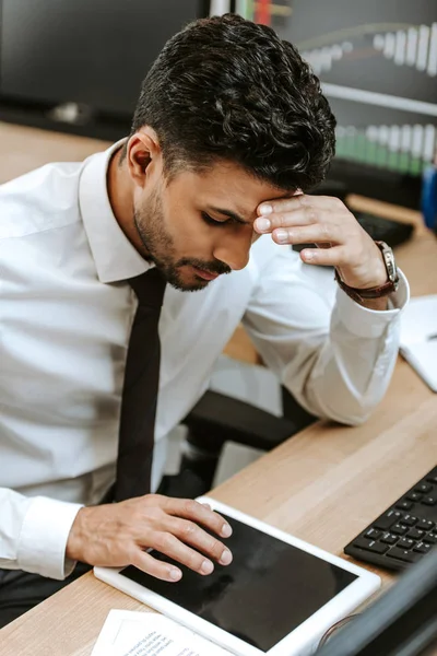 Vista ad alto angolo di trader bi-razziale pensoso utilizzando tablet digitale — Foto stock