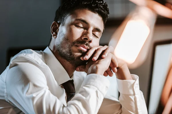 Vue de bas angle du beau commerçant bi-racial dormant dans le bureau — Photo de stock