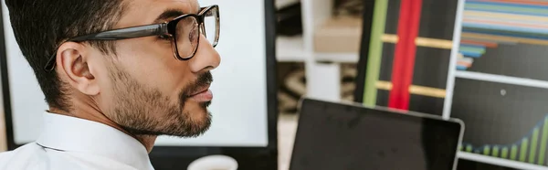 Tiro panorâmico de comerciante bi-racial em óculos olhando para longe — Fotografia de Stock