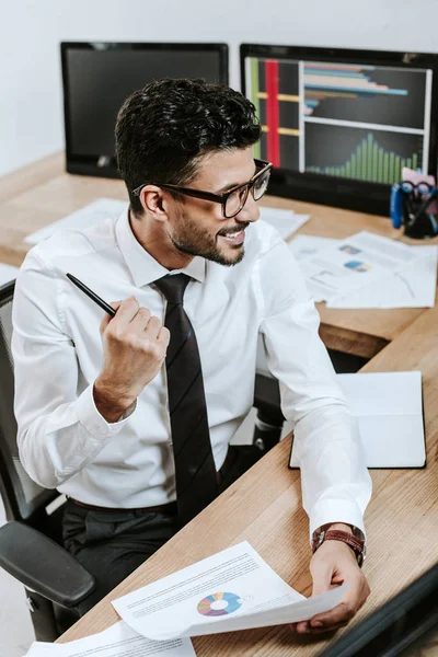 High angle view of bi-racial trader showing yes gesture and holding paper — Stock Photo