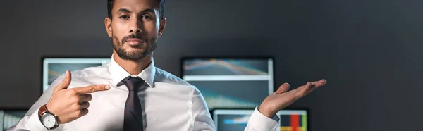Panoramic shot of bi-racial and handsome trader pointing with finger — Stock Photo