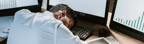 Panoramic shot of bi-racial trader sleeping on table in office — Stock Photo