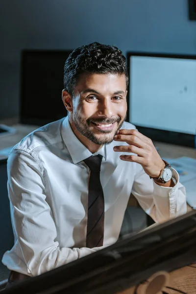 Enfoque selectivo de la sonrisa bi-racial comerciante mirando a la cámara - foto de stock