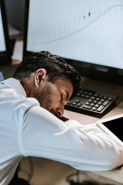 High angle view of handsome bi-racial trader sleeping on wooden table in office — Stock Photo