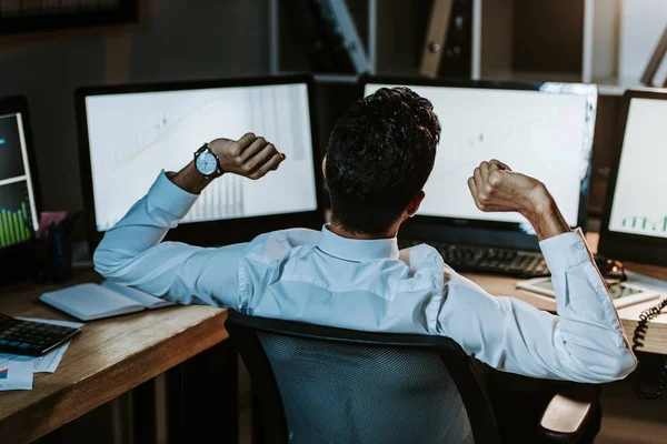 Rückseite des bi-rassischen Händlers, der Computer im Büro betrachtet — Stockfoto