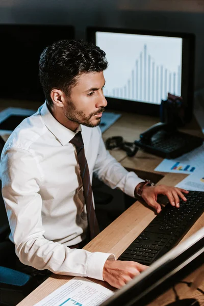 Vista ad alto angolo del commerciante bi-razziale utilizzando il computer e seduto a tavola — Foto stock