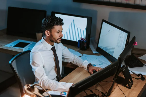 Vista de ángulo alto del comerciante bi-racial trabajando y sentado a la mesa - foto de stock