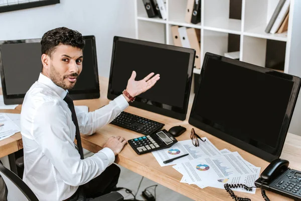 Angry bi-racial trader pointing with hand at computer with copy space — Stock Photo