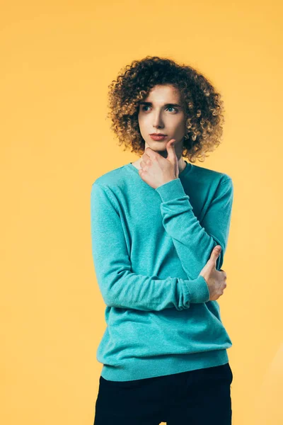 Pensive curly teenager looking away isolated on yellow — Stock Photo