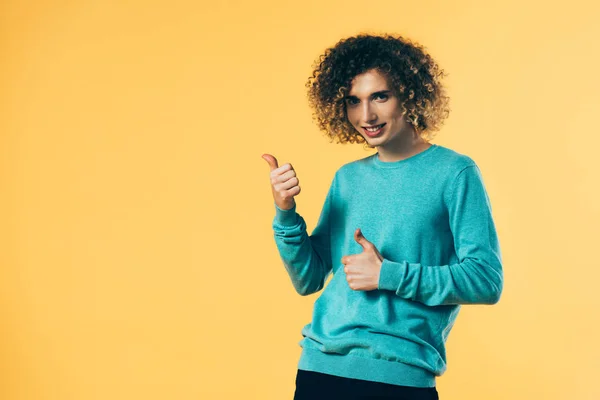 Adolescente encaracolado feliz mostrando polegares isolados no amarelo — Fotografia de Stock