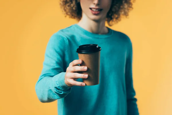 Selektiver Fokus des lockigen Teenagers, der Kaffee in Pappbecher hält, isoliert auf gelb — Stockfoto