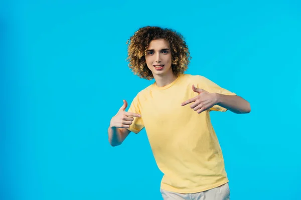 Rizado adolescente apuntando con los dedos a sí mismo aislado en azul - foto de stock