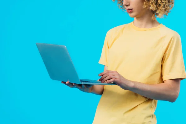 Cropped view of curly student using laptop isolated on blue — Stock Photo