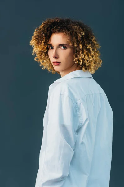 Back view of curly teenager in total white outfit isolated on green — Stock Photo
