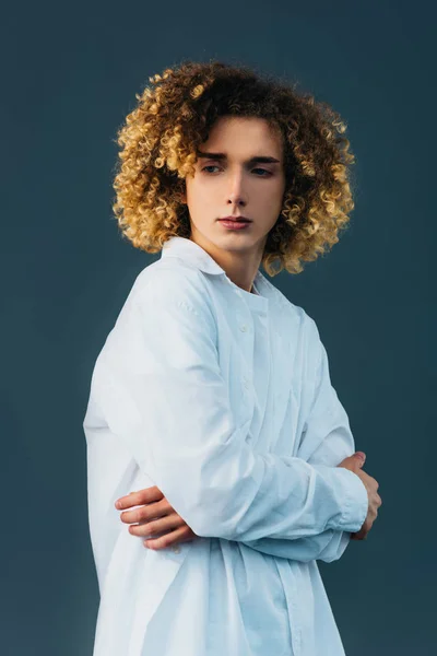 Triste adolescente riccio in total white outfit con braccia incrociate isolato su verde — Foto stock