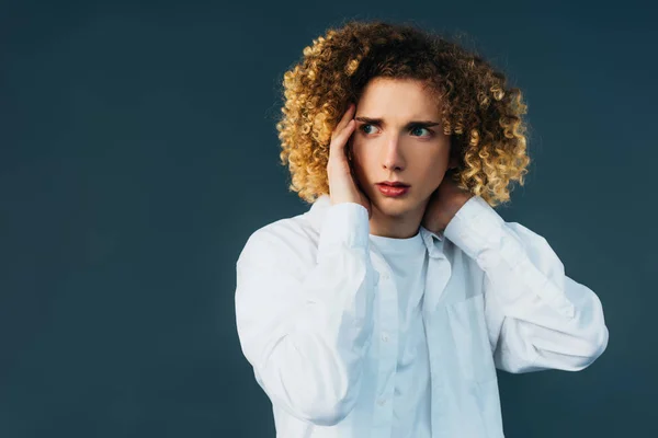 Stressed curly teenager in total white outfit looking away isolated on green — Stock Photo