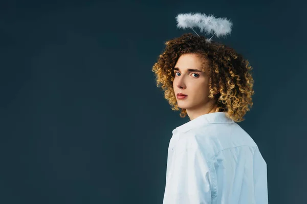 Visão traseira de adolescente encaracolado em traje de anjo com halo acima da cabeça isolado em verde — Fotografia de Stock