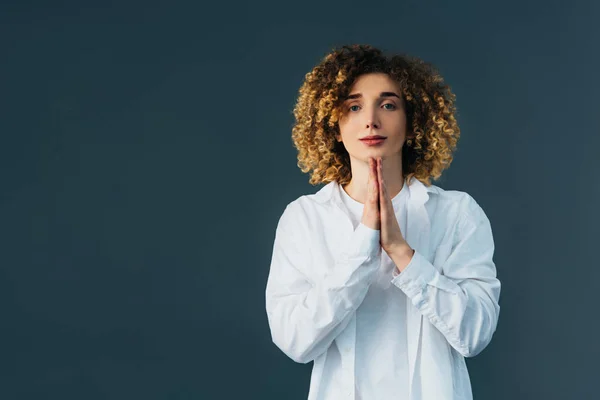 Elegante adolescente riccio in total white outfit con le mani in preghiera isolate sul verde — Foto stock